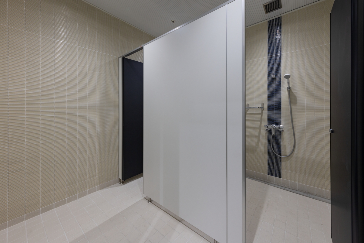 沼津市総合体育館の清潔な個室シャワールーム。プライバシーが保たれた空間で、練習や試合でかいた汗を流せる。快適なタイル張りの壁と最新のシャワー設備が特徴。